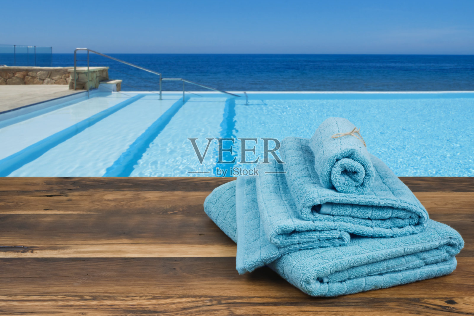 木制毛巾盖上模糊的游泳池和大海背景照片摄影图片
