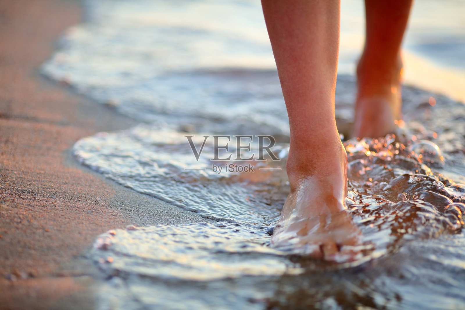 女人的脚踩在海浪上照片摄影图片