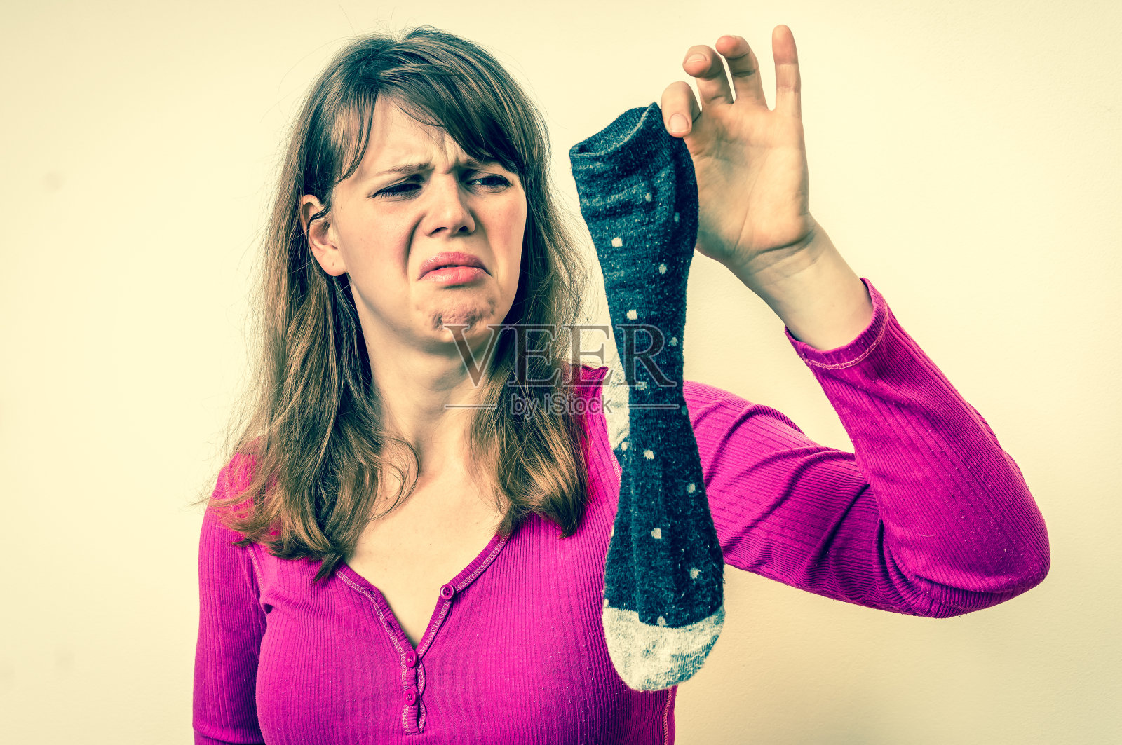 女人拿着脏臭的袜子照片摄影图片