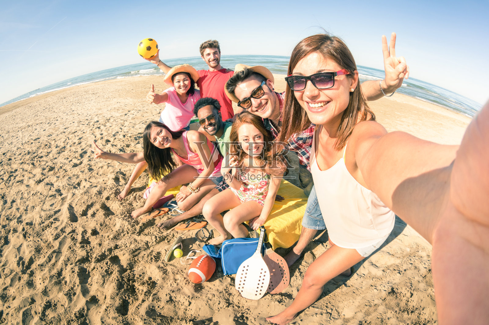 一群多种族的快乐的朋友在海滩自拍的乐趣照片摄影图片