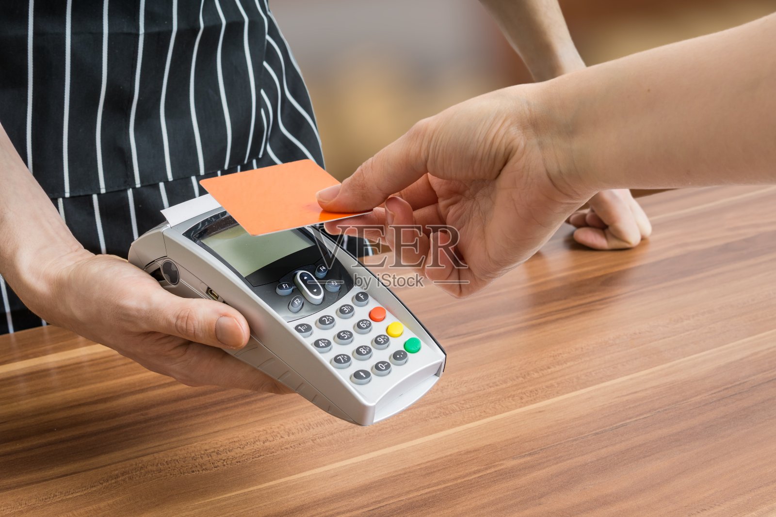 顾客在店内使用非接触式信用卡付款。照片摄影图片