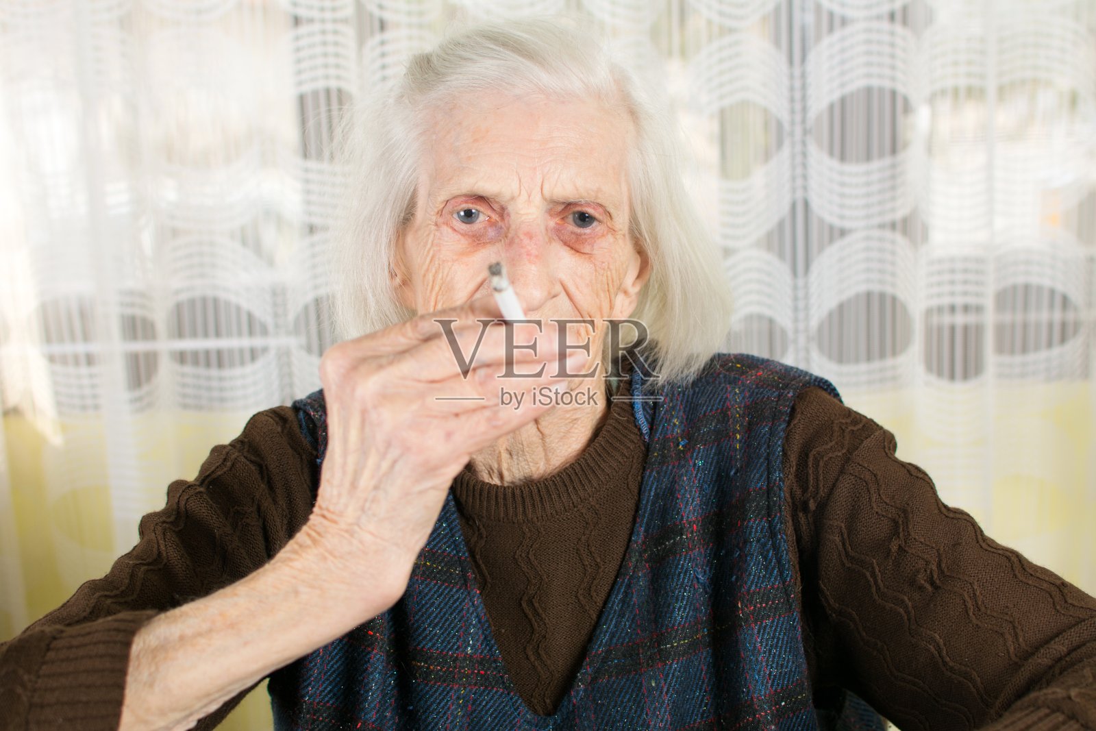 奶奶在家里抽烟照片摄影图片