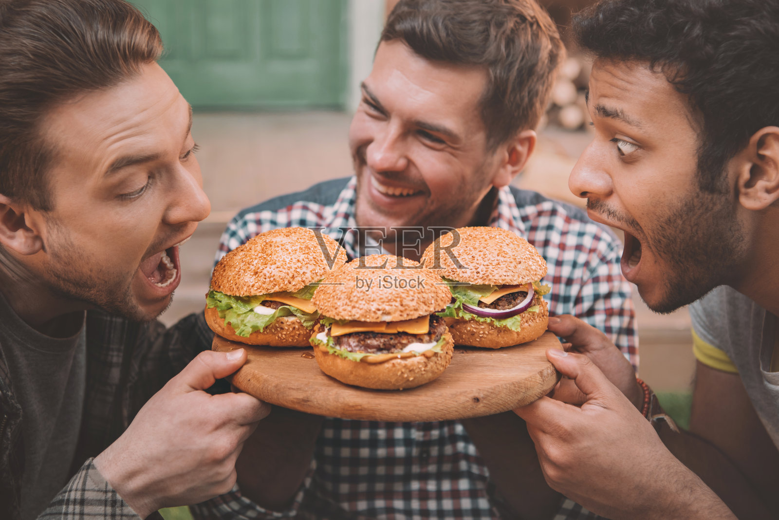 兴奋的年轻人吃着新鲜美味的汉堡照片摄影图片