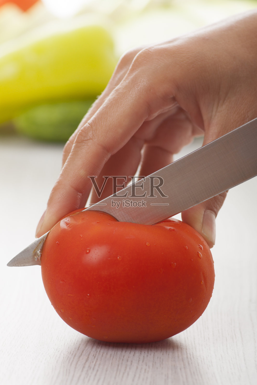 女性用刀，切西红柿照片摄影图片