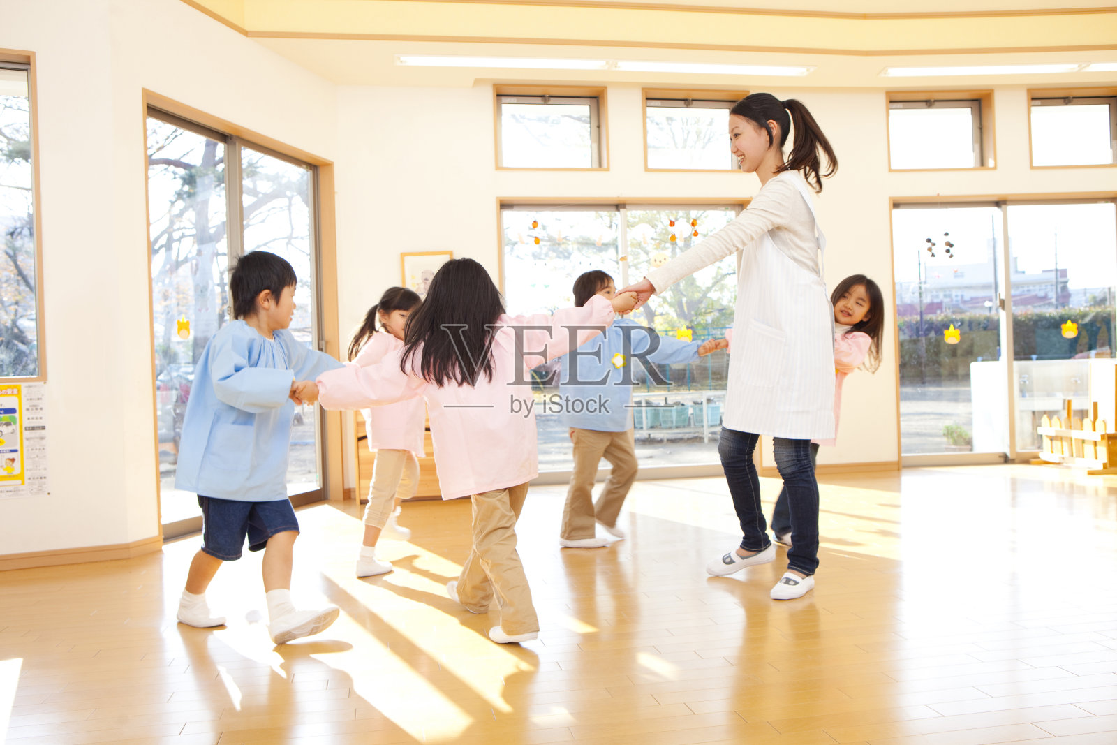 幼儿园和幼儿园的老师们，围成一圈跳舞照片摄影图片