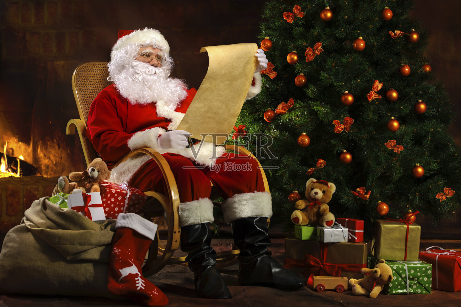 圣诞老人坐在壁炉前照片摄影图片