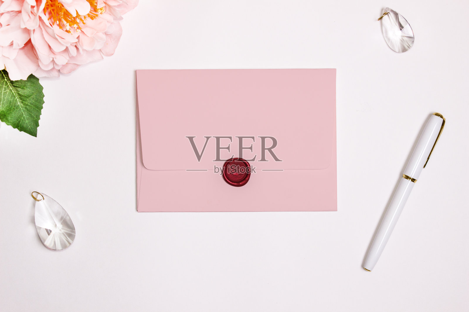 粉色的矩形翻盖信封，Mockup。蜡印、笔、花、婚饰。照片摄影图片