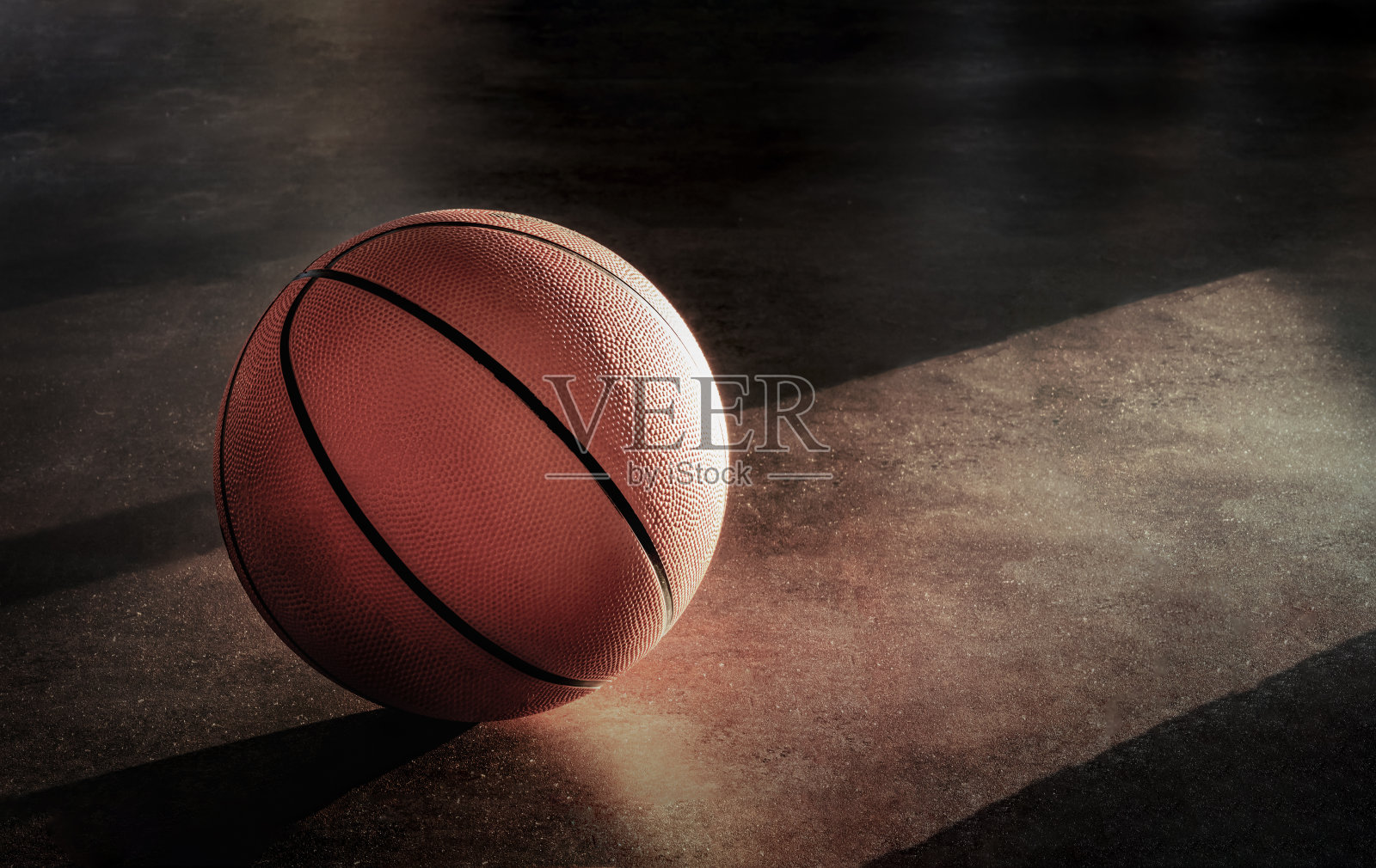 篮球躺在地板上，显得很寂寞。照片摄影图片