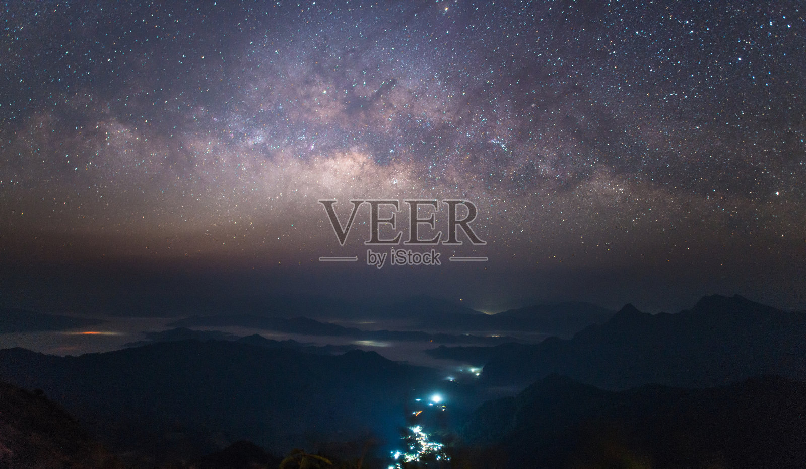 美丽的银河在繁星点点的夜晚俯瞰着泰国的乡村风光。照片摄影图片