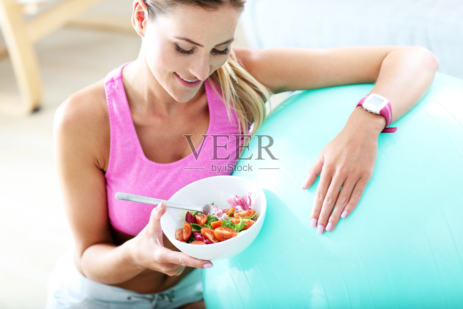 年轻女子在锻炼后吃健康的沙拉照片摄影图片