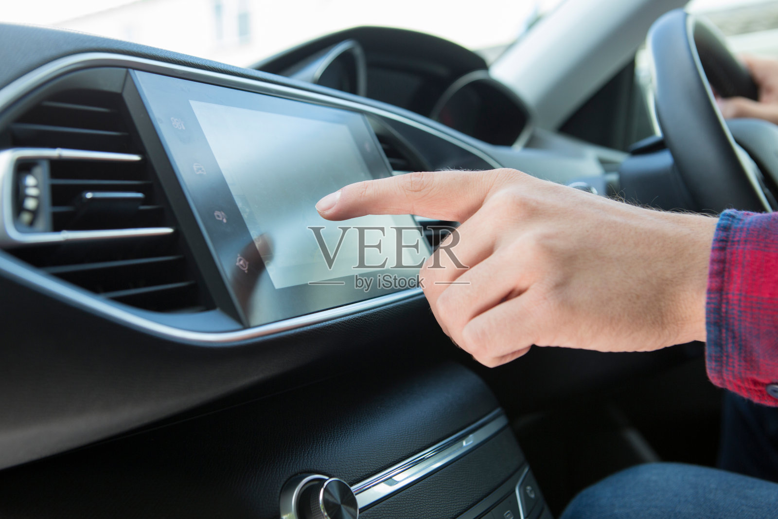 在汽车中使用触摸屏的司机的特写照片摄影图片