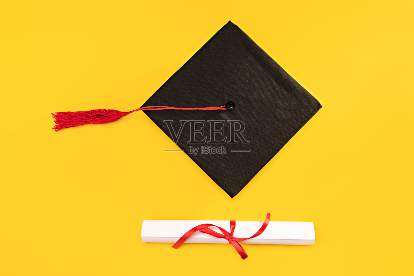 俯视毕业学位帽和毕业证书上的黄色背景，教育理念照片摄影图片