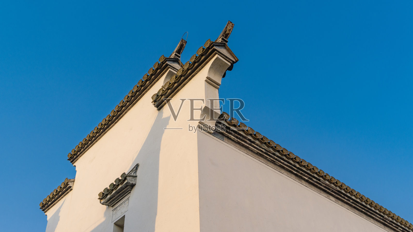 马头墙采用青砖青瓦的传统安徽建筑，用于分隔私人庭院和火灾时，以纯净的蓝天为背景。照片摄影图片
