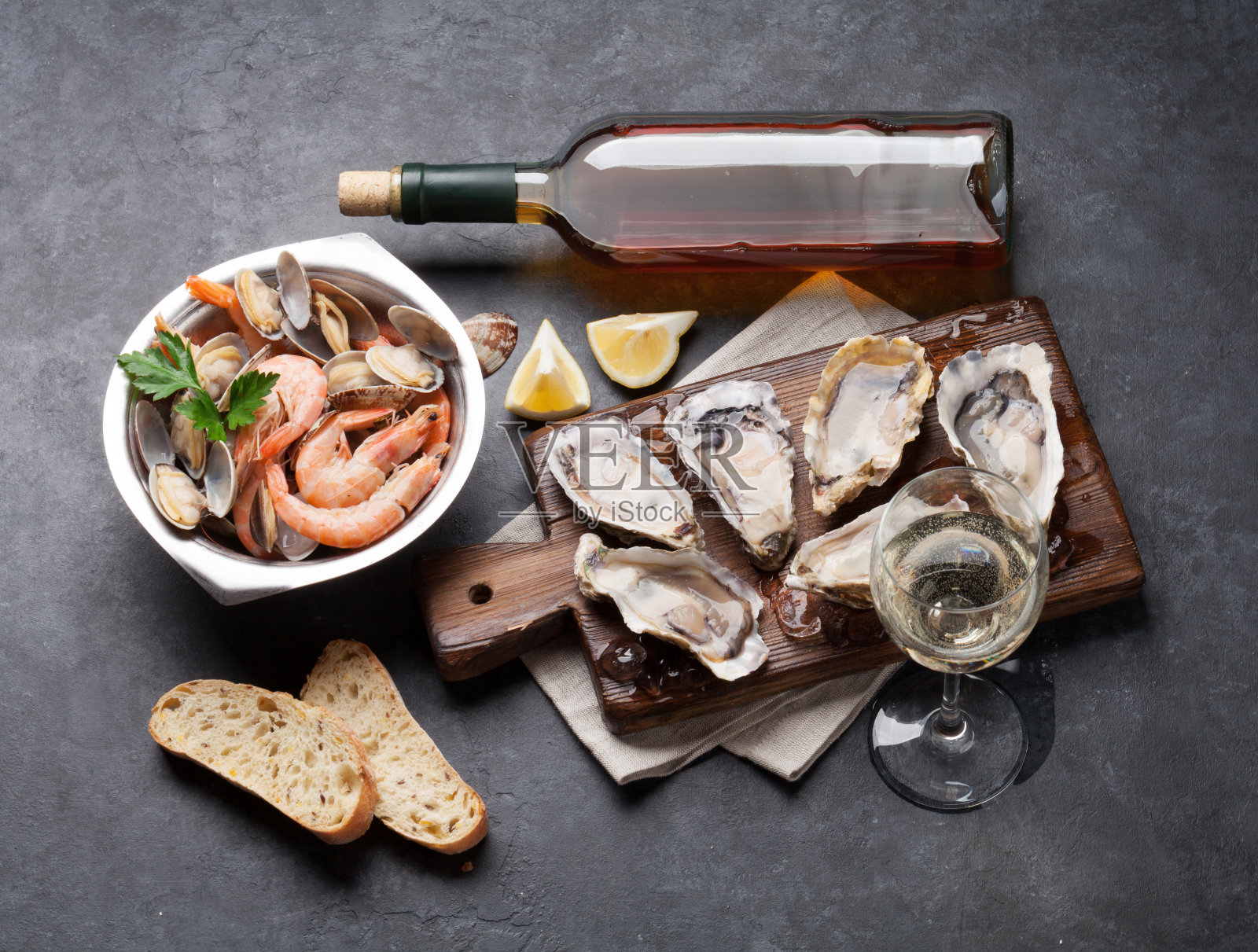 新鲜的海鲜和白葡萄酒在石头桌上照片摄影图片