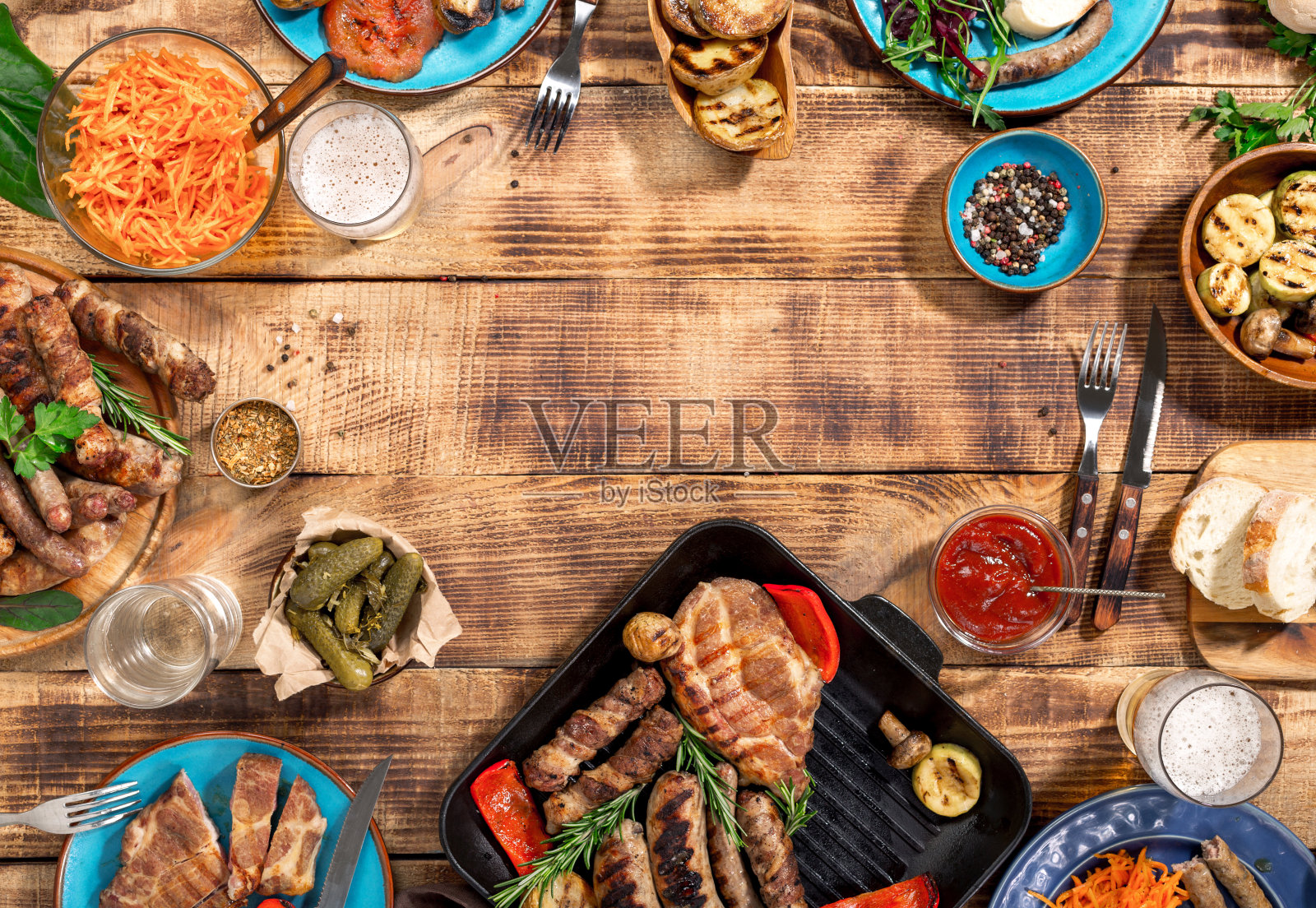 开胃的烧烤牛排，香肠和烤蔬菜在一个木制的野餐桌上复印空间照片摄影图片