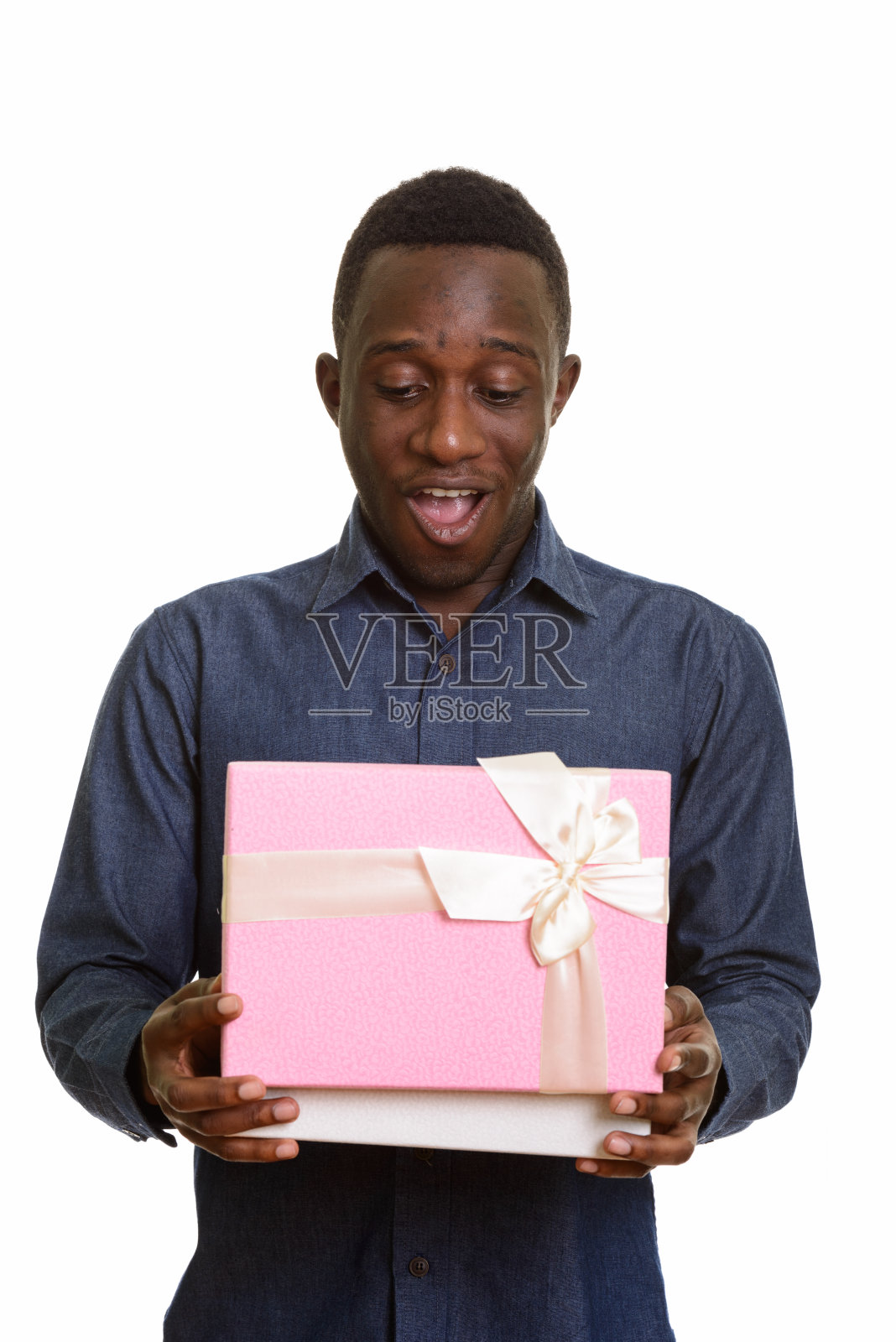 年轻快乐的非洲男子微笑着打开礼盒，看起来很震惊照片摄影图片