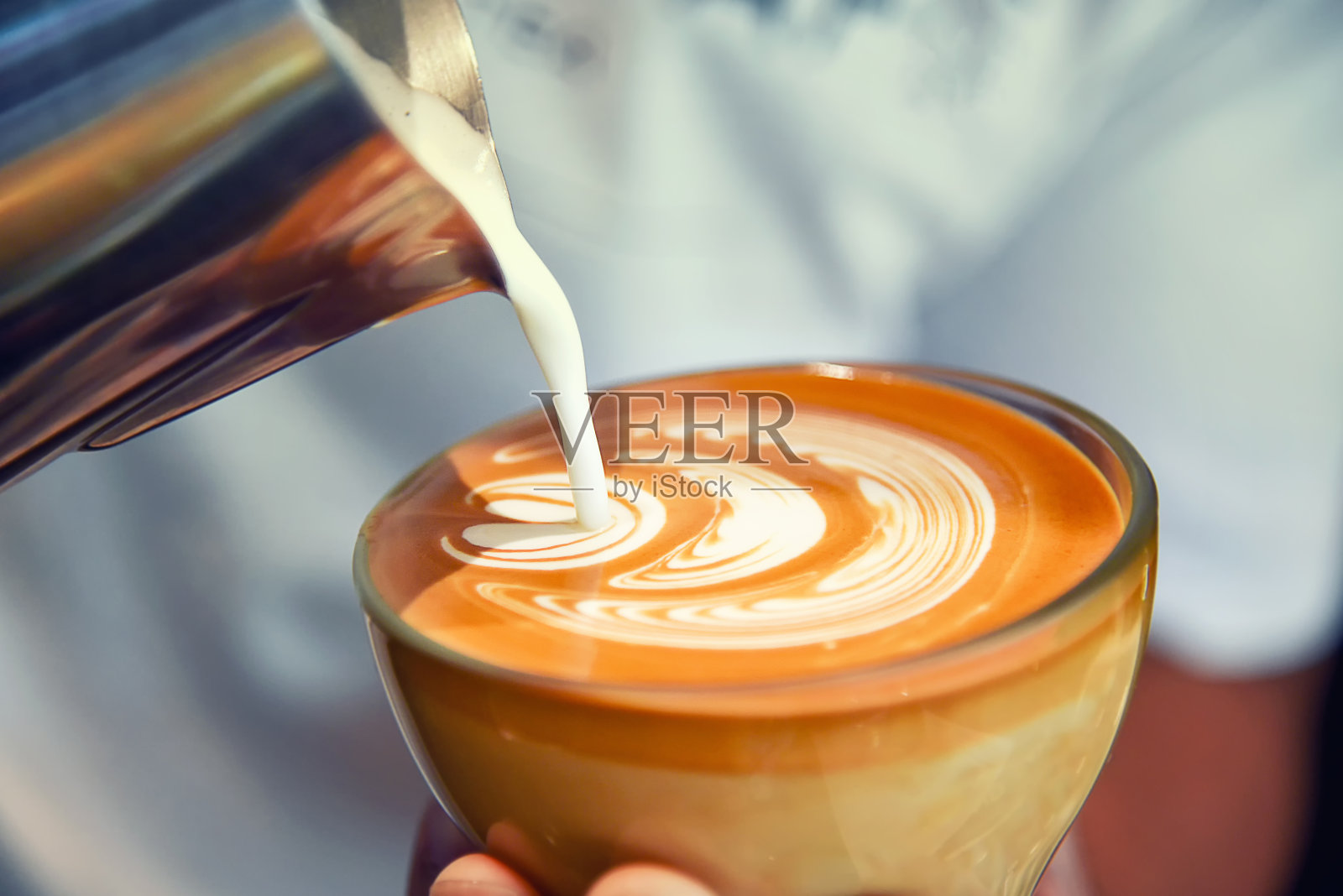 咖啡师在咖啡店和餐厅用咖啡机准备新鲜的咖啡或拉花艺术并倒入杯子照片摄影图片