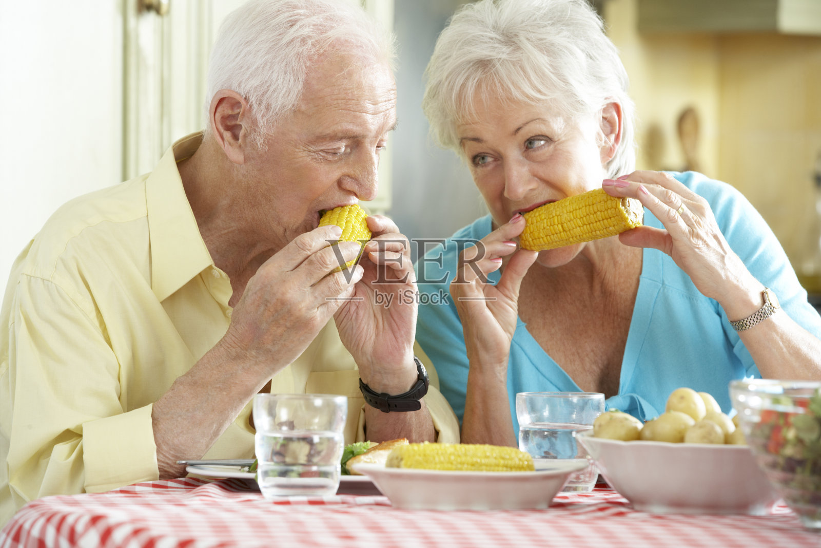 老夫妇在厨房一起吃饭照片摄影图片