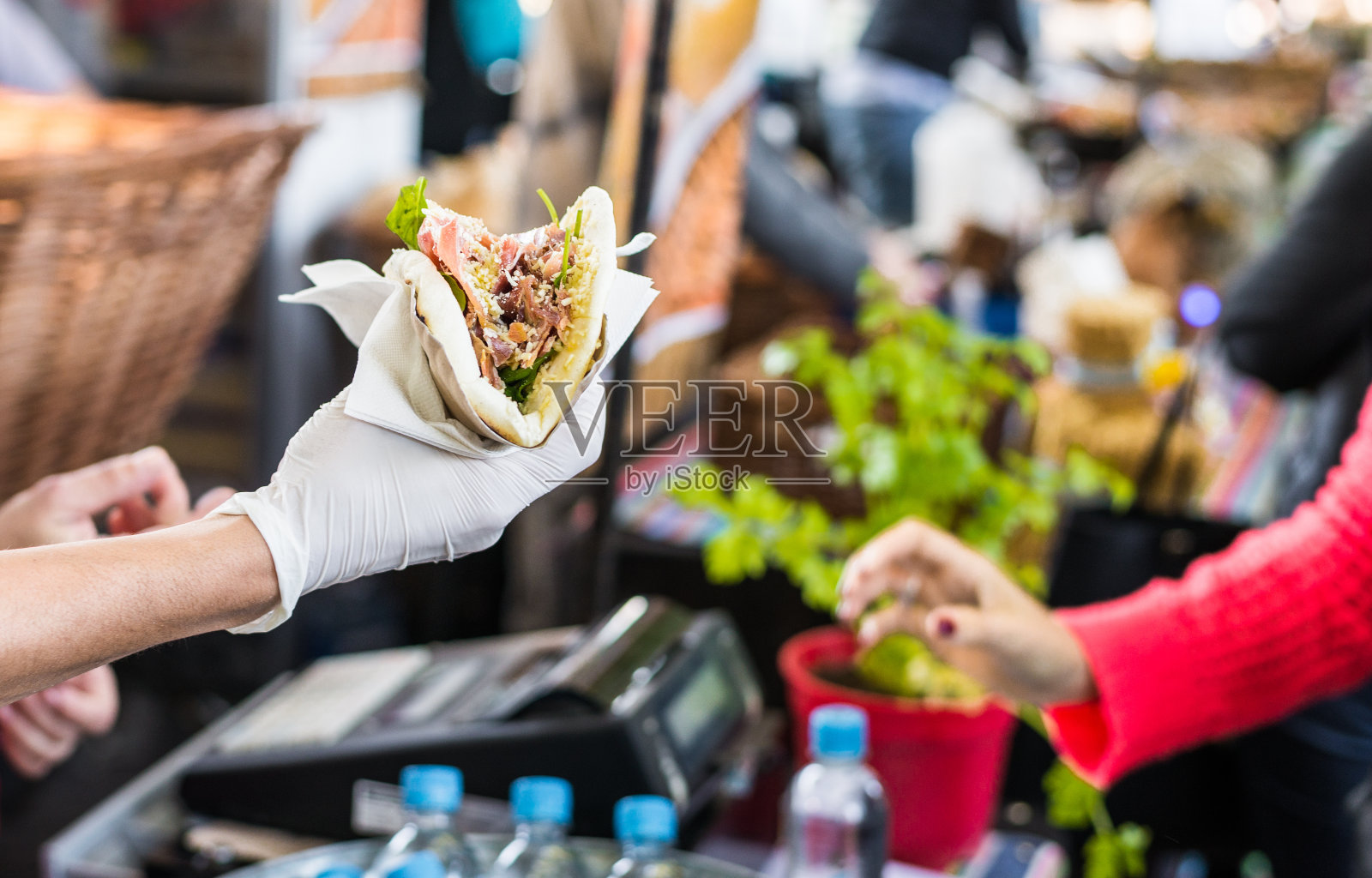 在街头小吃市场，厨师将玉米饼递给美食家照片摄影图片