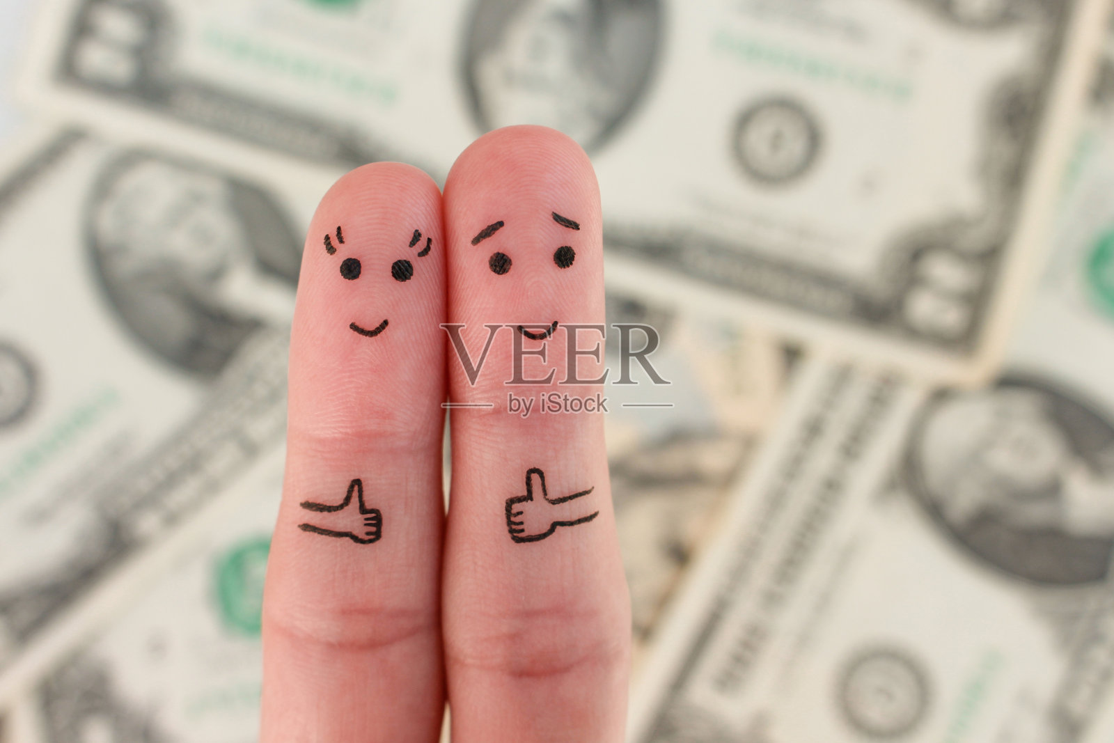 幸福夫妻的手指艺术。男人和女人在金钱背景下显示阶级的标志。照片摄影图片
