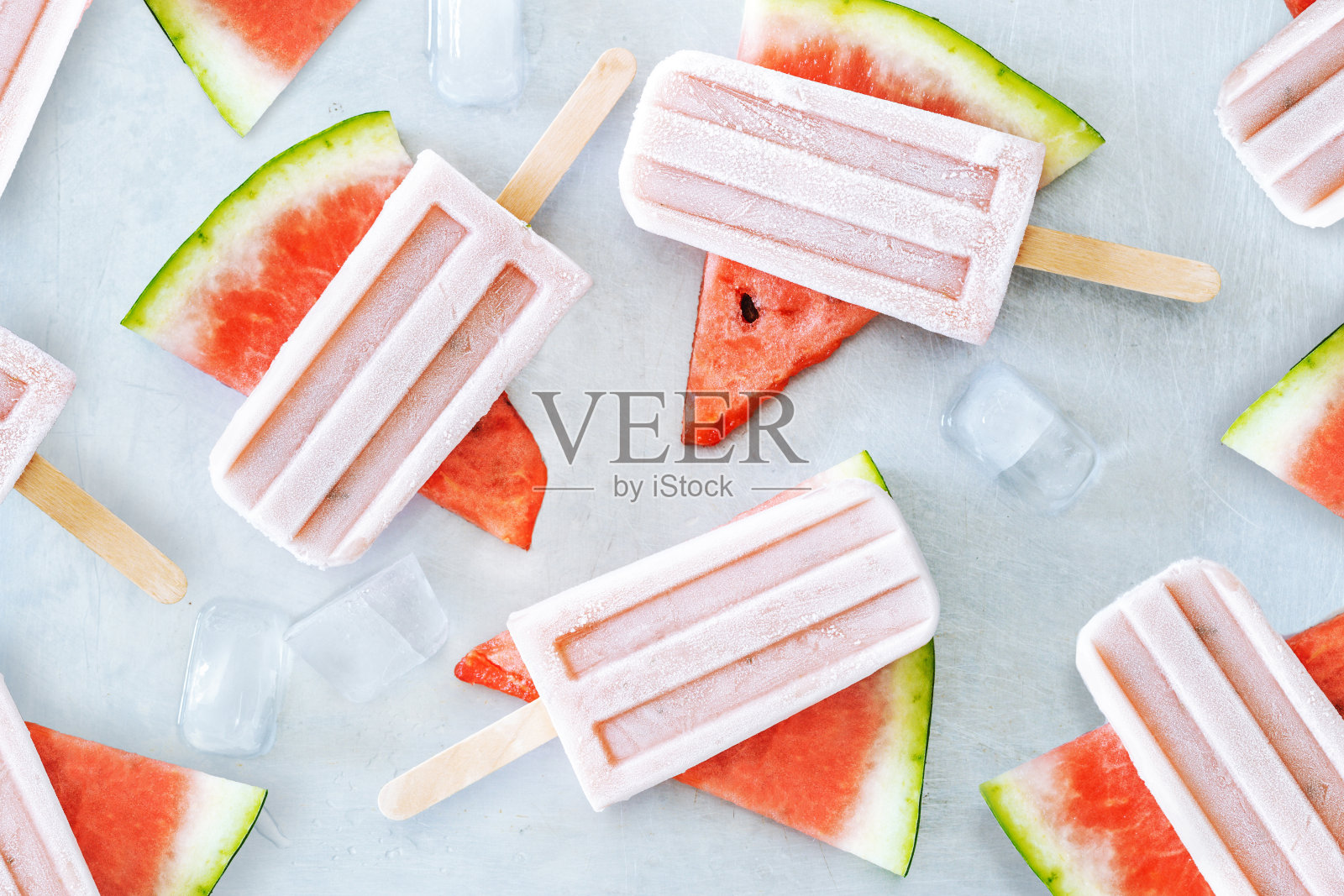 天然西瓜汁冰棒与冰块在灰色背景。夏季健康的甜点。照片摄影图片