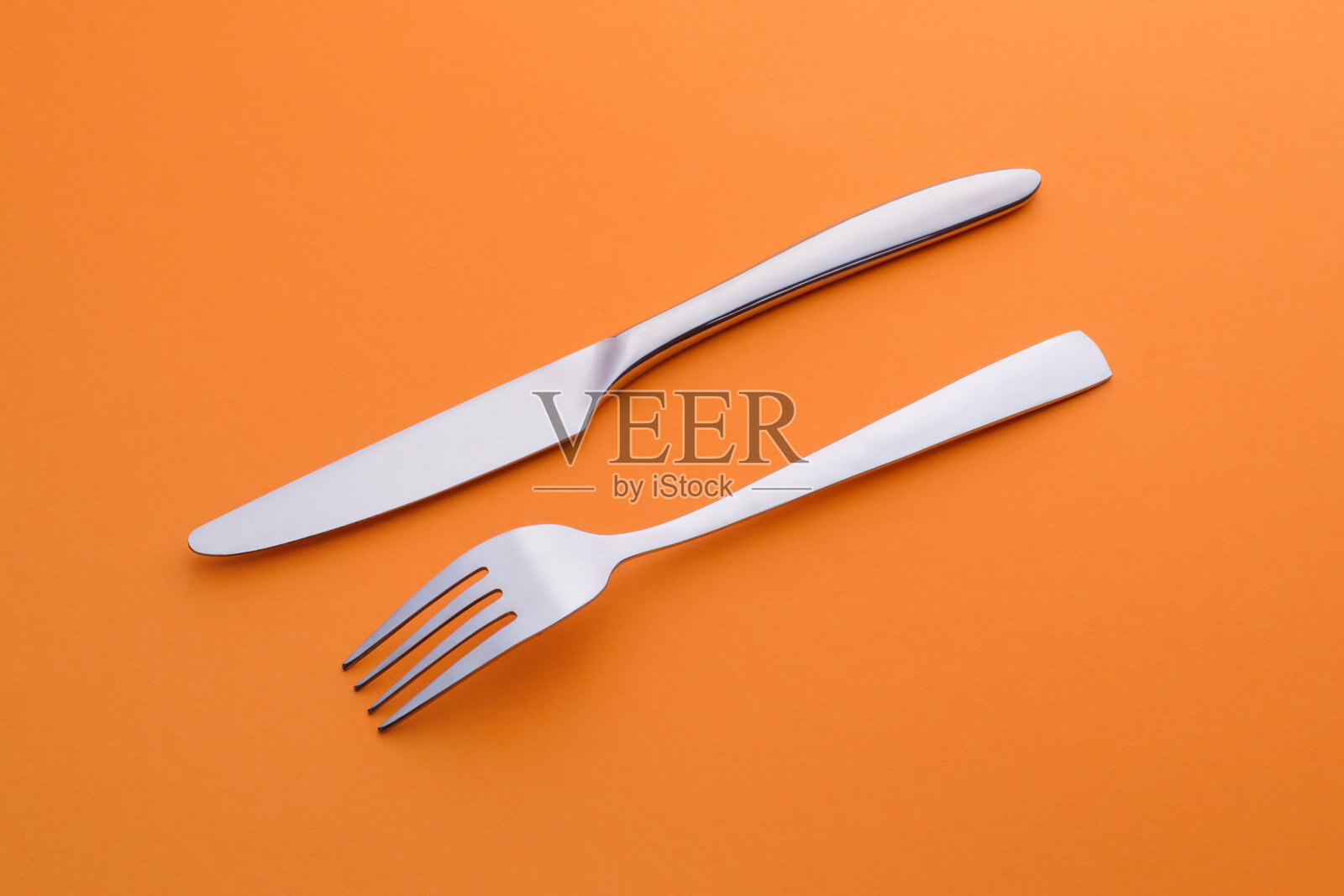 叉子和刀的背景是橙色的照片摄影图片