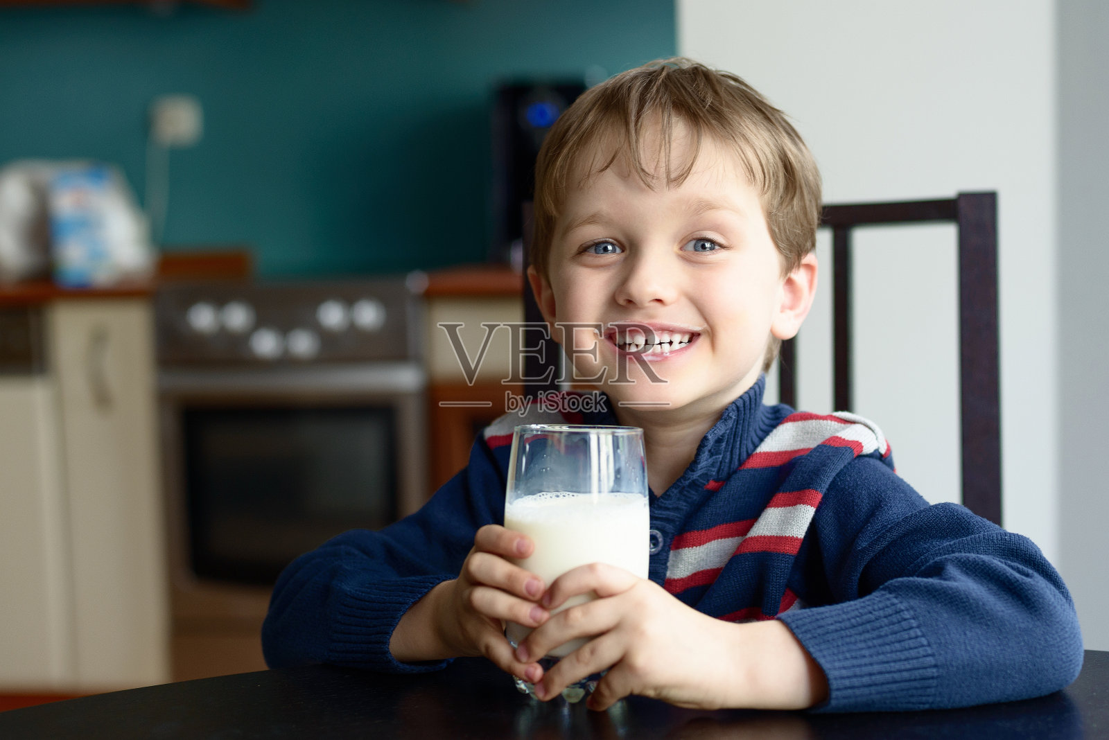 微笑的男孩拿着一杯健康的新鲜牛奶照片摄影图片