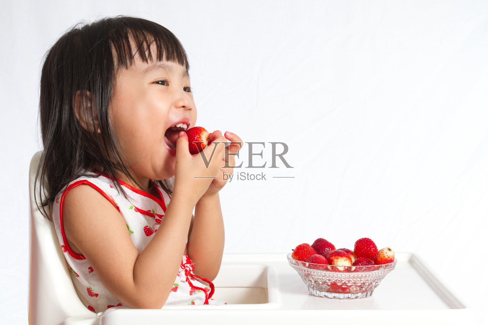亚洲华人小女孩在吃草莓照片摄影图片