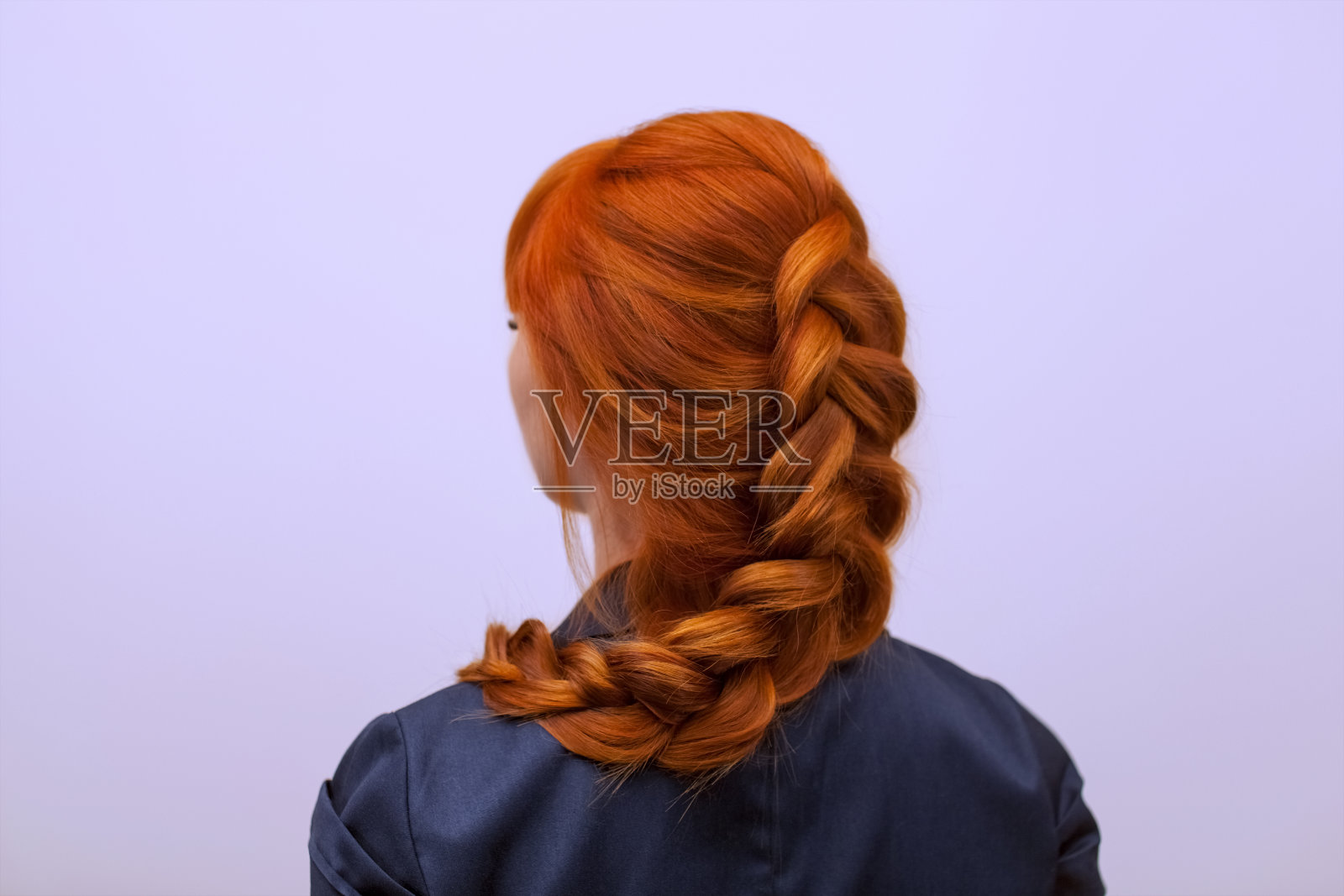 一个漂亮的女孩，一头长长的红发，梳着一个法式辫子，正在美容院里。照片摄影图片