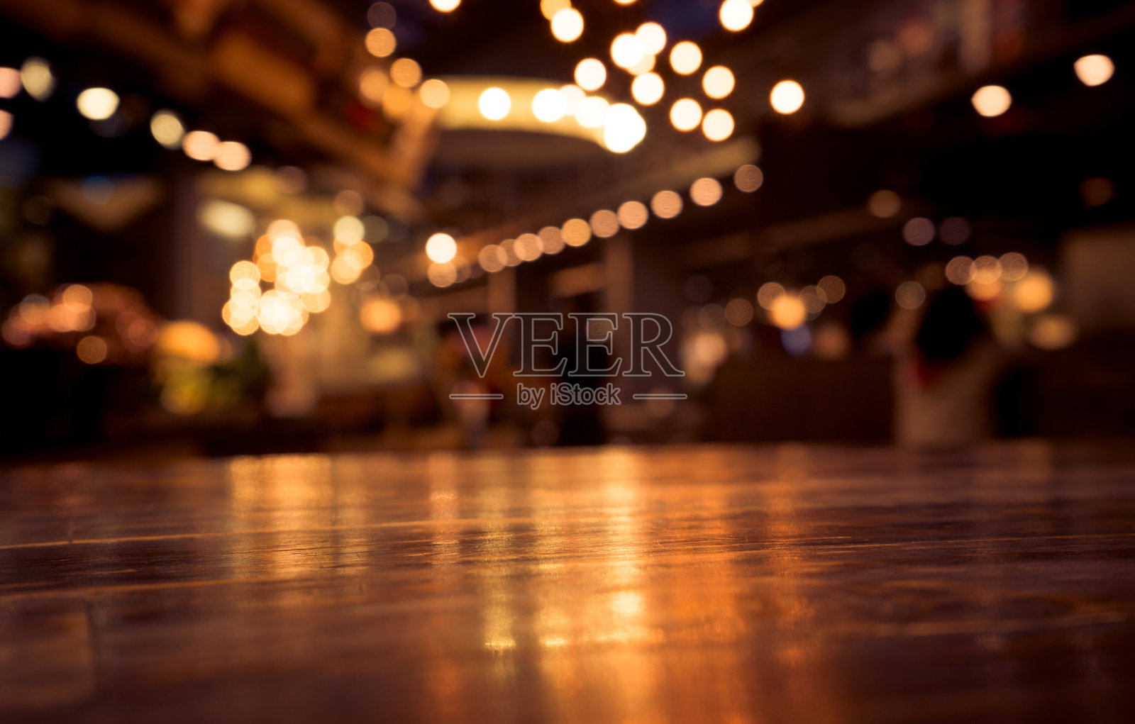 木质桌子上模糊的咖啡馆(酒吧)与灯光背景背景图片素材