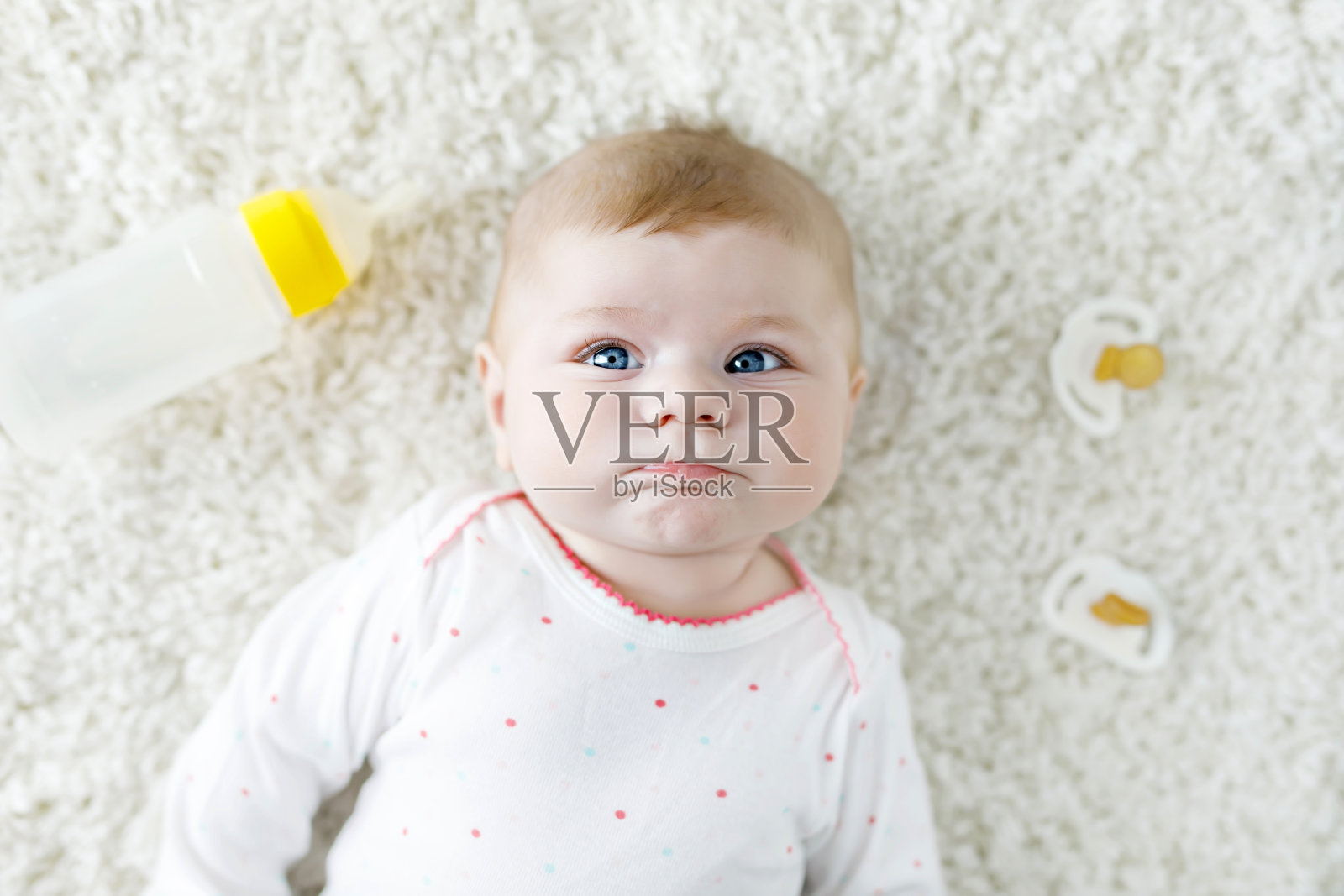 可爱可爱的新生女婴抱着奶瓶，喝着配方奶照片摄影图片