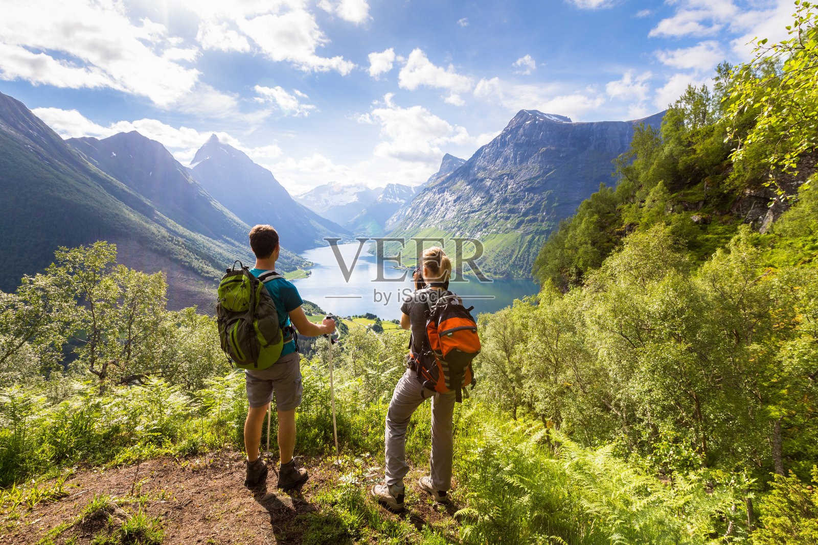 两个徒步者在有湖的山上看风景，阳光明媚的夏天照片摄影图片
