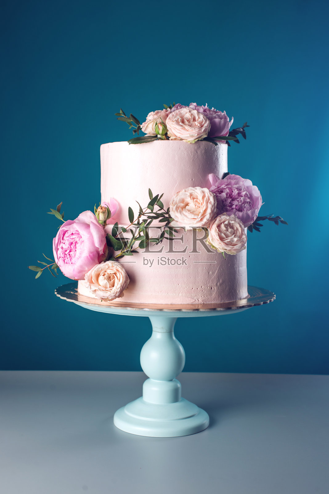 用新鲜玫瑰装饰的粉色奶油婚礼蛋糕照片摄影图片