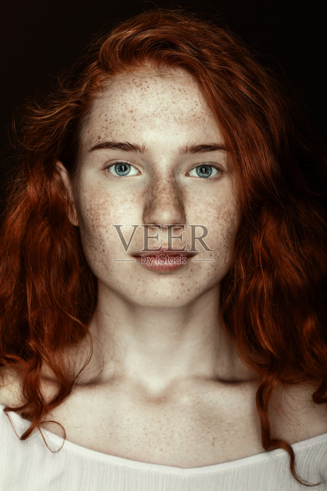 雀斑红发女人的肖像看着照相机，孤立在黑色照片摄影图片