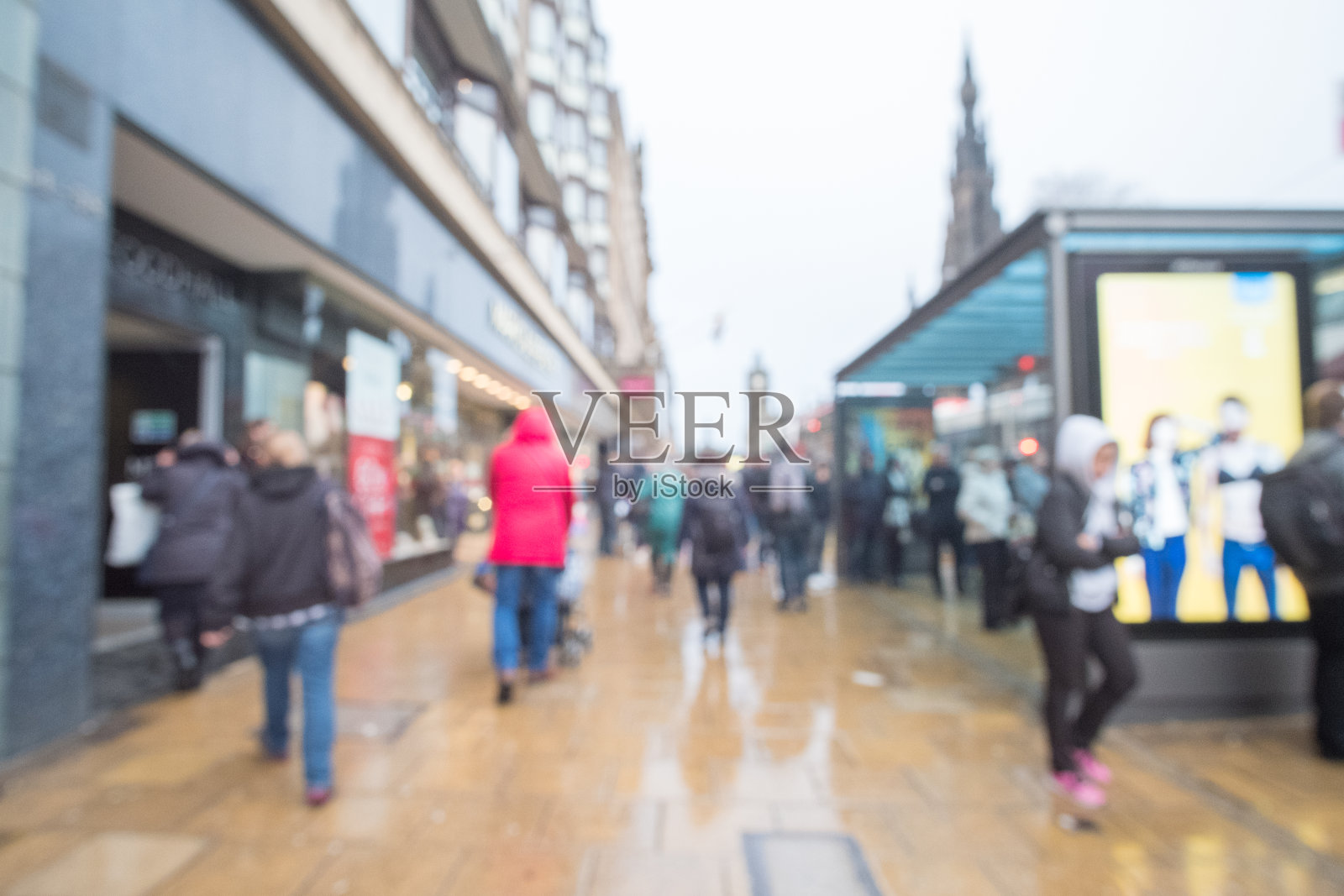 模糊形象的人走在街上，与汽车，建筑的背景。在王子街，爱丁堡的主要购物街，英国。照片摄影图片