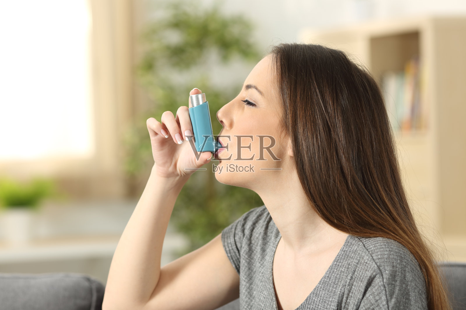 哮喘妇女使用吸入器照片摄影图片