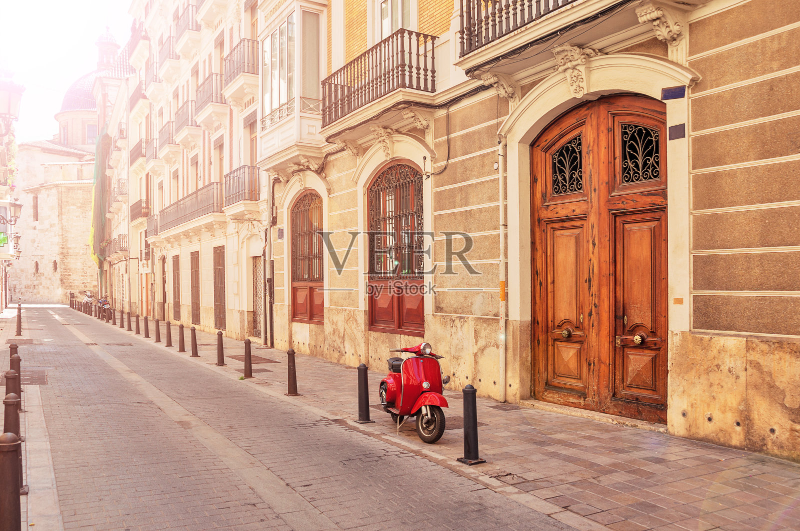 西班牙。瓦伦西亚。巴伦西亚旅游城市的一条街道。红色的摩托车,助力车。旅游的概念。的旅程。红色老式摩托车停在人行道上。照片摄影图片