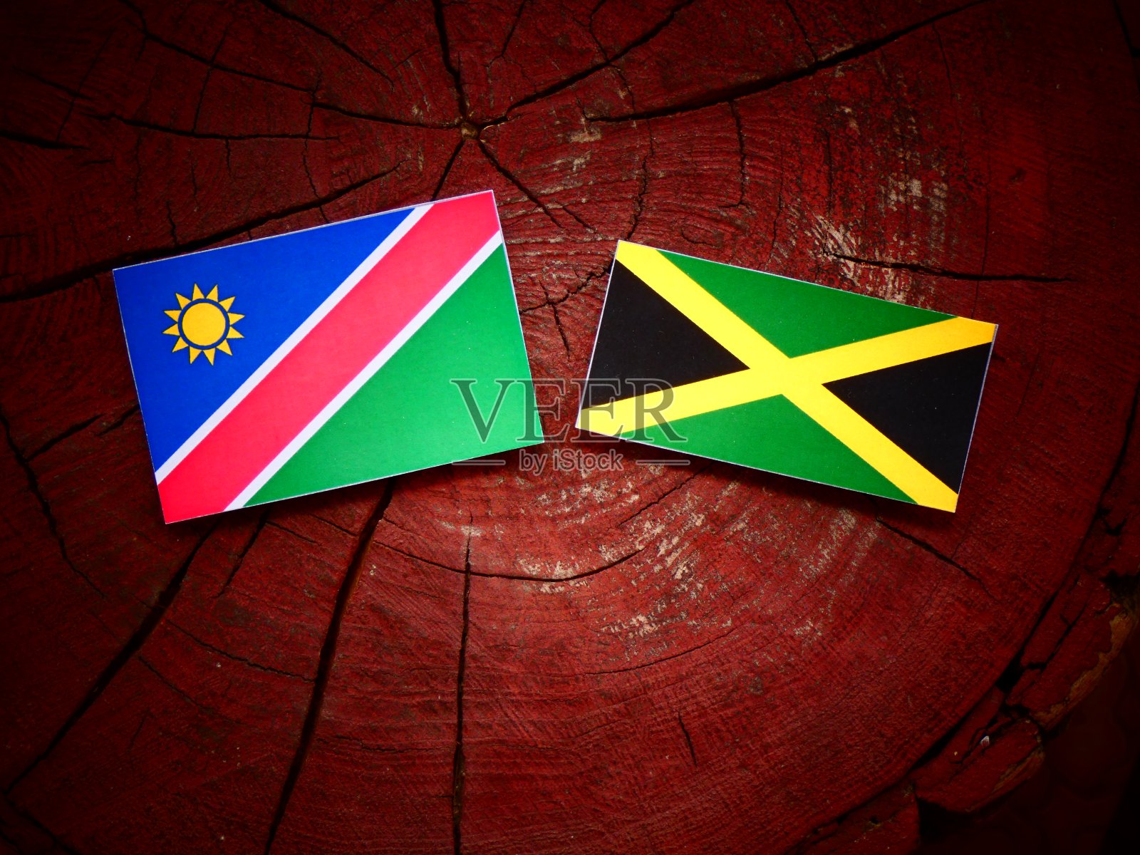 纳米比亚国旗和牙买加国旗在一个孤立的树桩上照片摄影图片