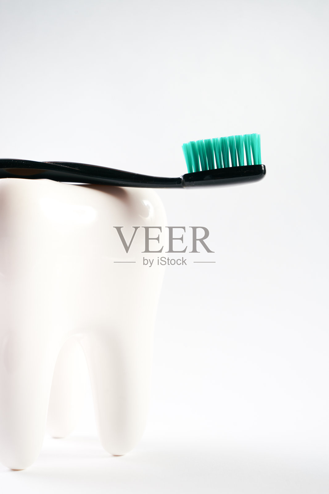 白色健康陶瓷牙齿和黑色现代牙刷隔离在白色背景与复制空间。日常口腔卫生，牙科概念照片摄影图片