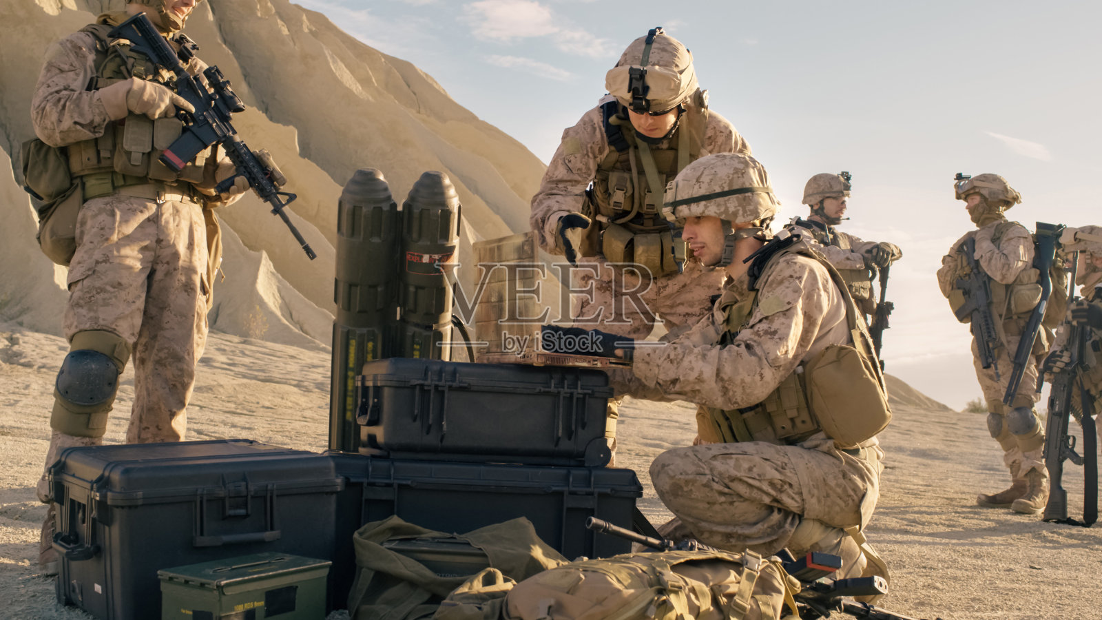 在沙漠军事行动中，士兵们正在使用笔记本电脑进行监视。照片摄影图片