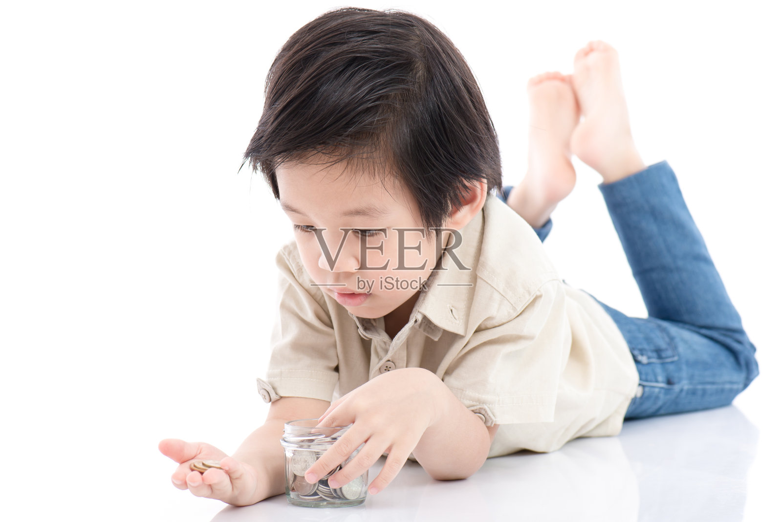 可爱的亚洲孩子在玻璃瓶里存钱照片摄影图片