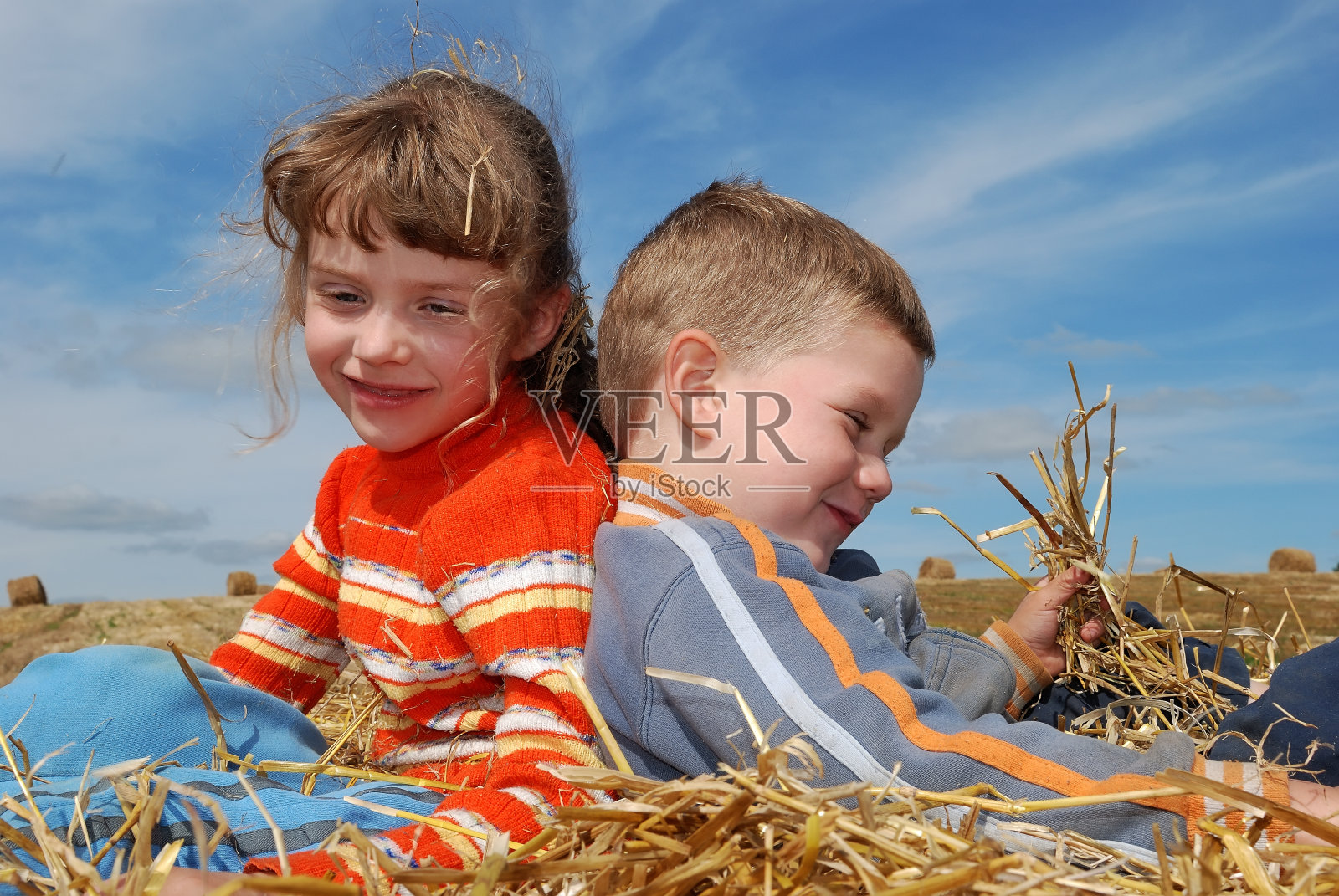 两个微笑的孩子在户外的稻草照片摄影图片