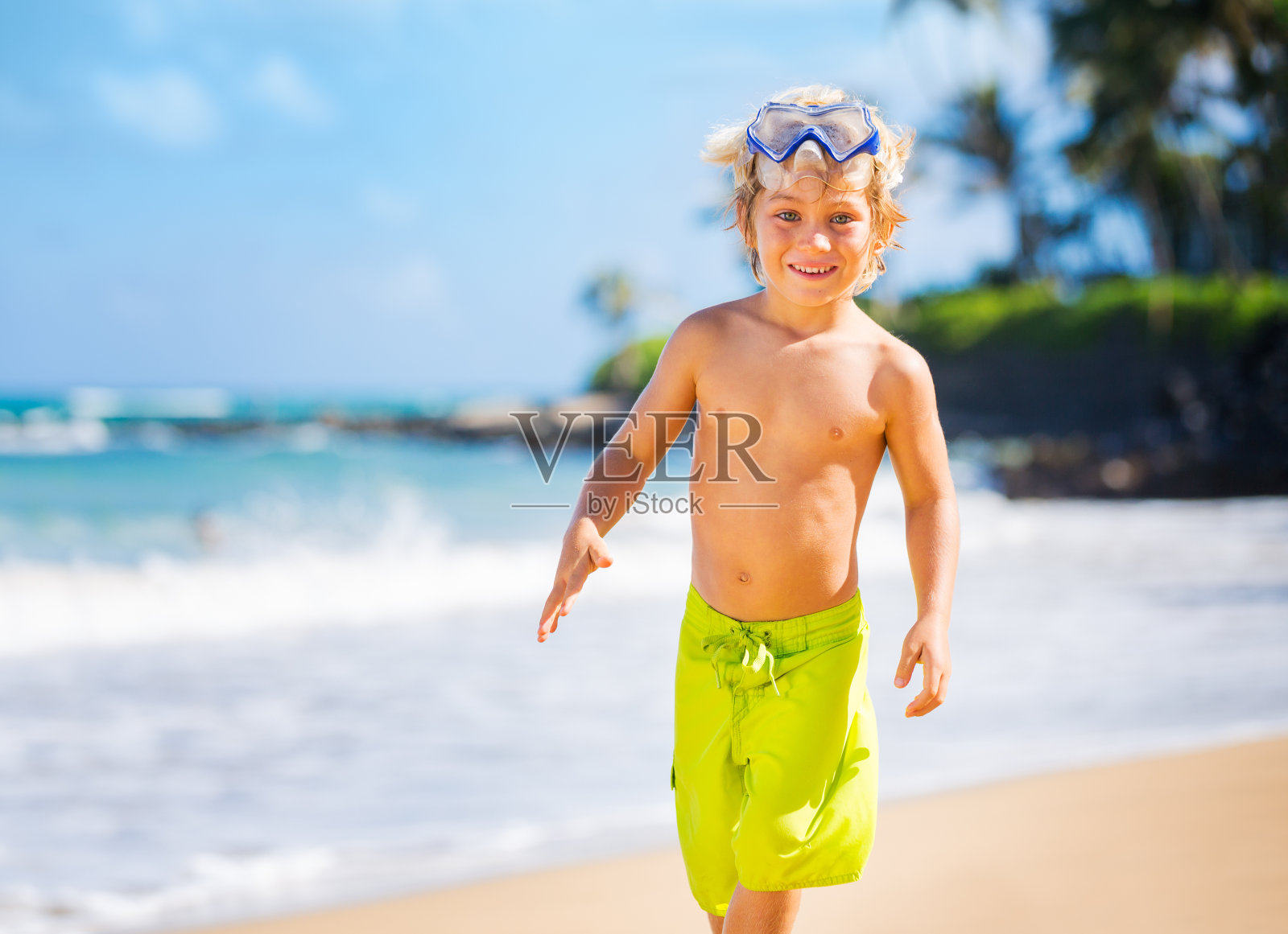 海滩上快乐的小男孩照片摄影图片