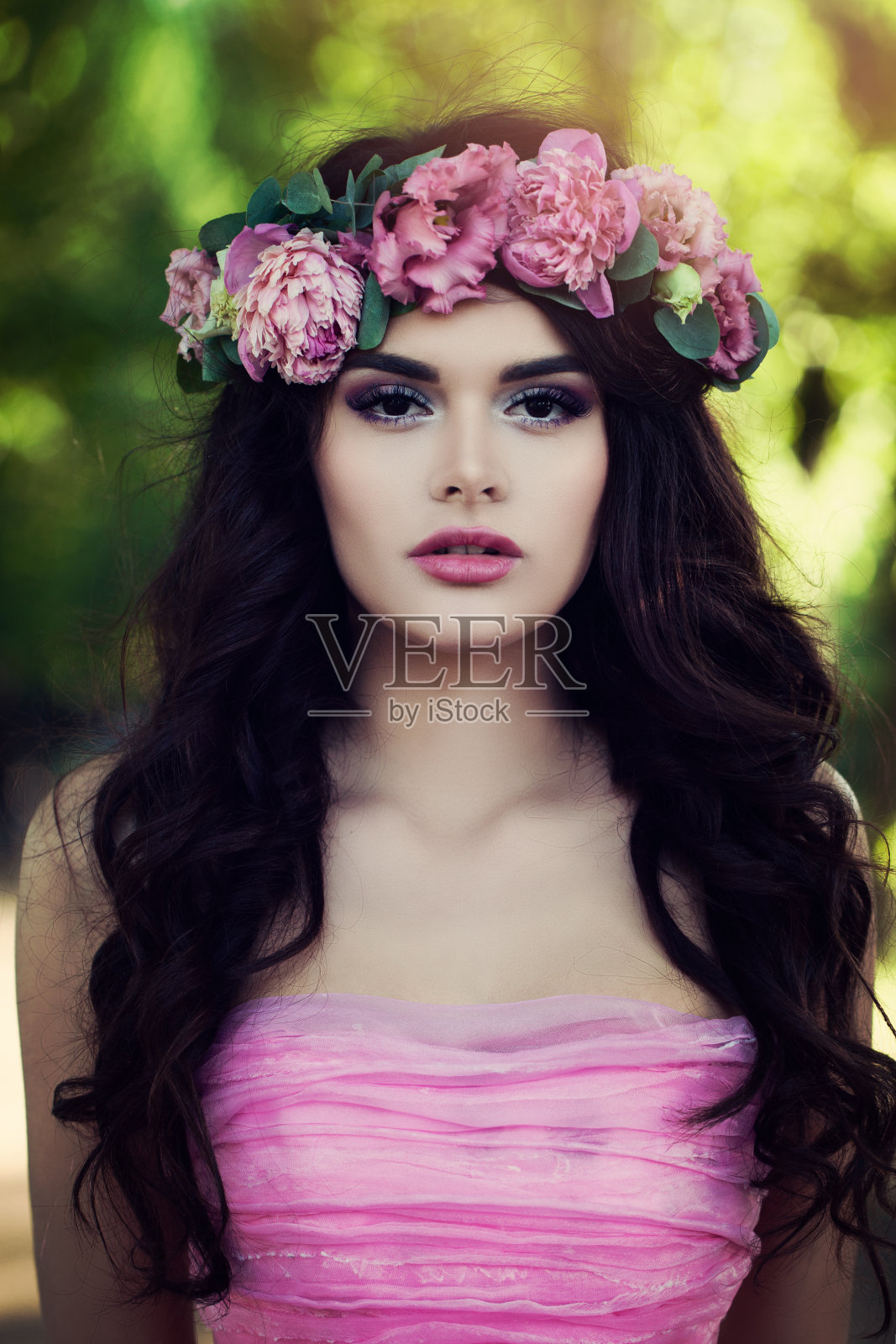 完美的黑发模特穿着粉红色连衣裙与鲜花户外照片摄影图片
