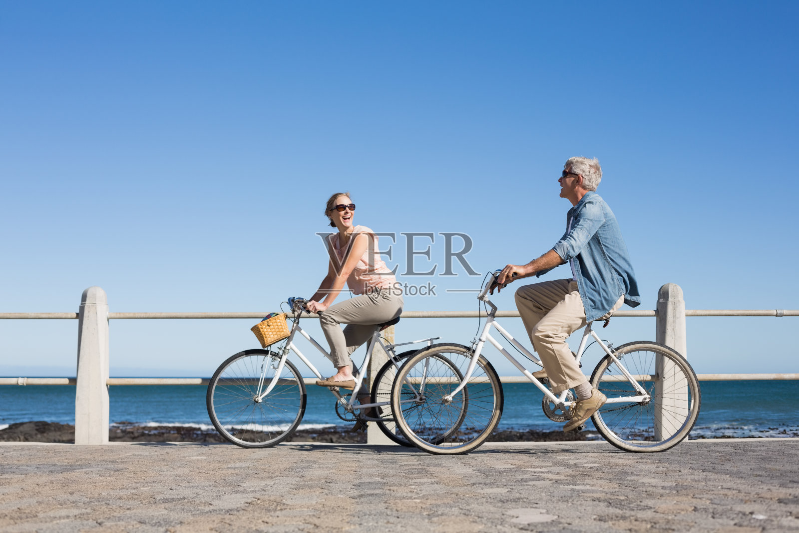 快乐随意的情侣在码头上骑自行车照片摄影图片