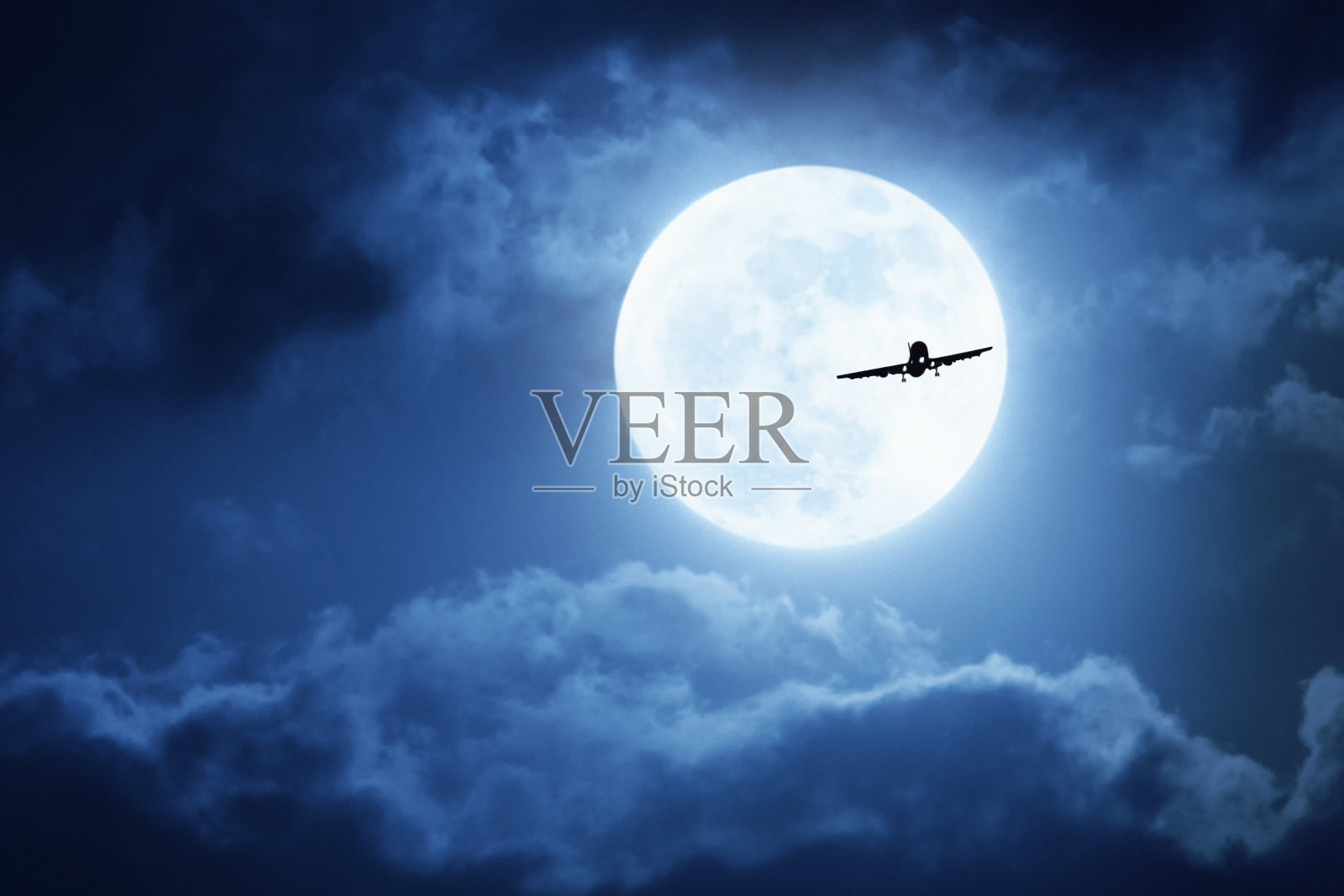 戏剧性的夜空，巨大的蓝色满月和商业飞机照片摄影图片