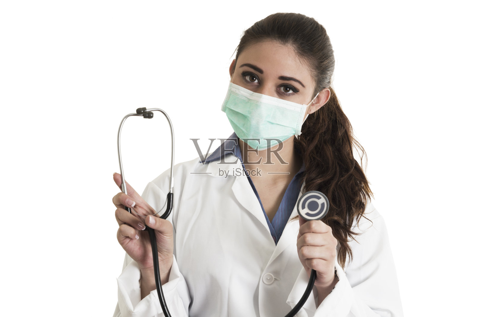 年轻漂亮的女医生戴着口罩，拿着听诊器照片摄影图片