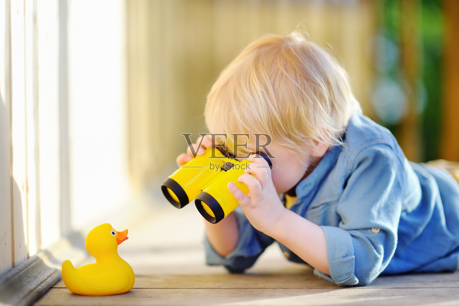 可爱的小男孩在户外玩橡皮鸭和塑料望远镜照片摄影图片
