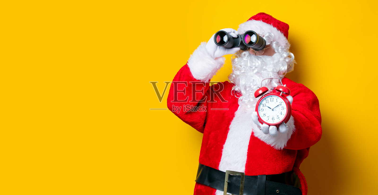 圣诞老人拿着望远镜和闹钟照片摄影图片