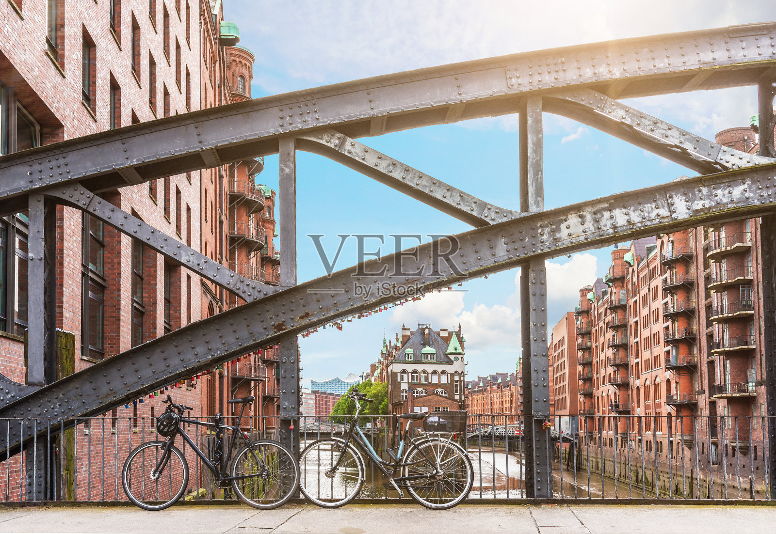 自行车停在一座桥的铁栏杆上，在德国汉堡的旧仓库区Speicherstadt照片摄影图片